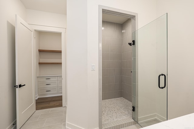 bathroom with hardwood / wood-style flooring and a shower with door