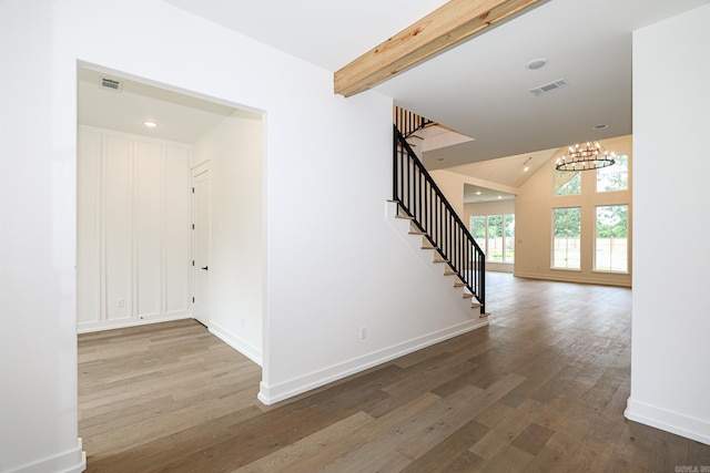 interior space featuring a chandelier, wood-type flooring, and lofted ceiling with beams