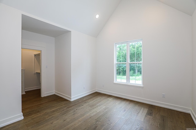 empty room with high vaulted ceiling and dark wood-type flooring