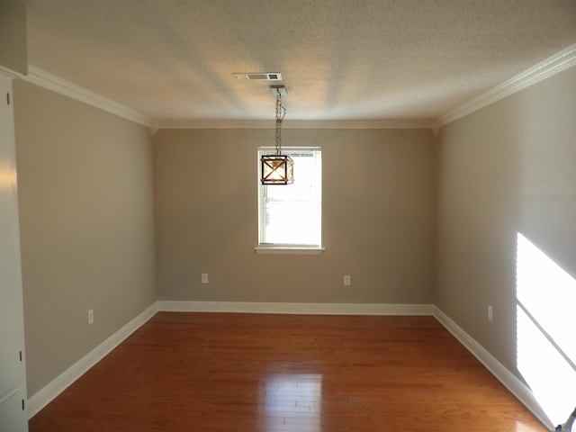 empty room featuring hardwood / wood-style flooring, crown molding, and a textured ceiling