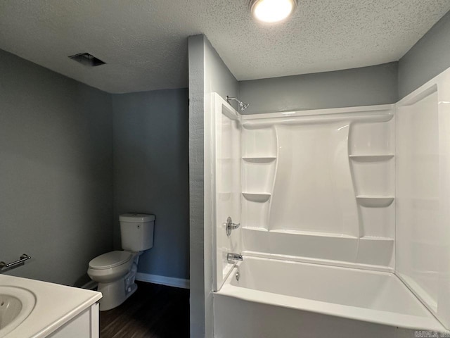 full bathroom featuring vanity, shower / washtub combination, toilet, a textured ceiling, and wood-type flooring