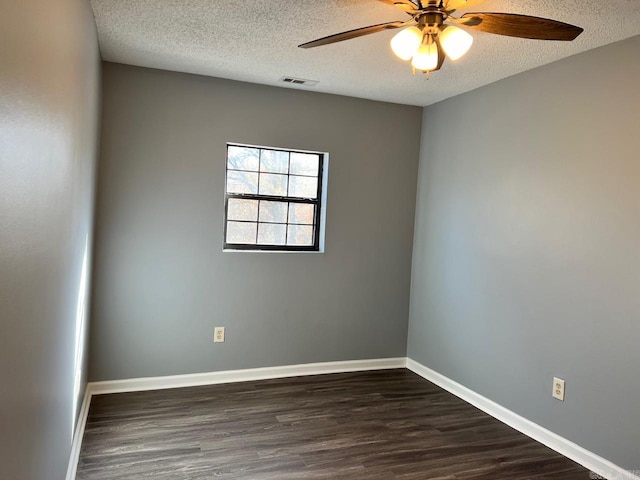 spare room with a textured ceiling, ceiling fan, and dark wood-type flooring