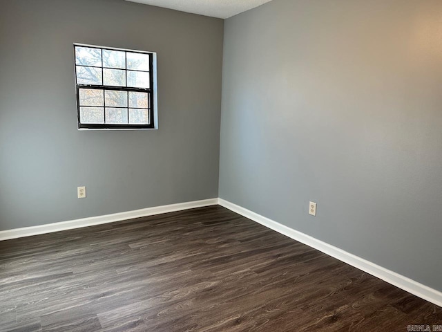 unfurnished room with a textured ceiling and dark hardwood / wood-style floors