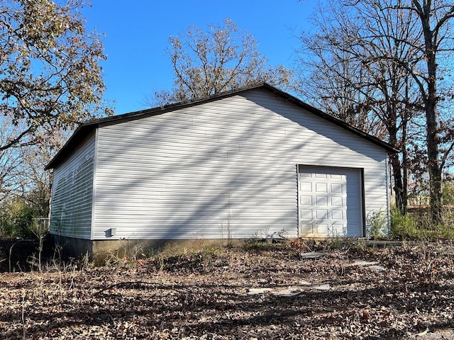 view of property exterior featuring a garage and an outdoor structure