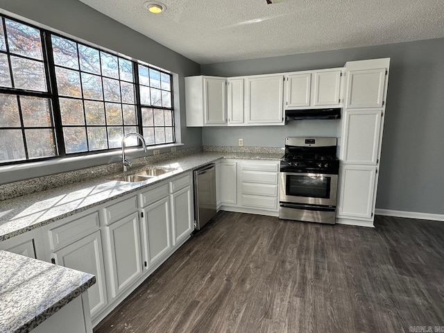 kitchen featuring white cabinetry, sink, dark wood-type flooring, stainless steel appliances, and a textured ceiling