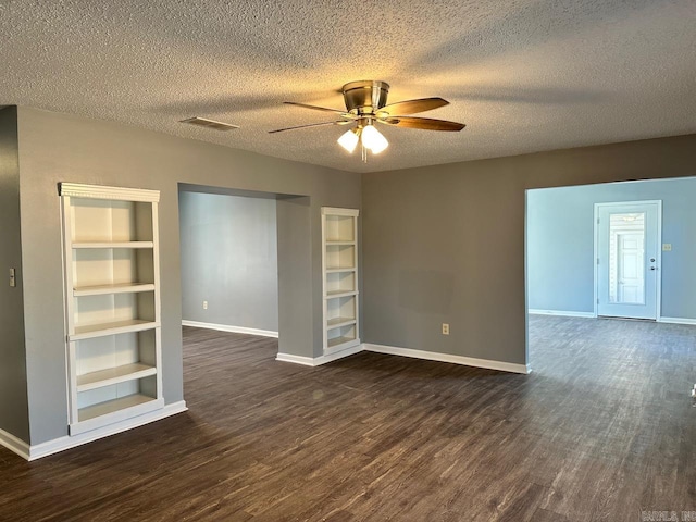 unfurnished room with built in shelves, ceiling fan, dark hardwood / wood-style flooring, and a textured ceiling