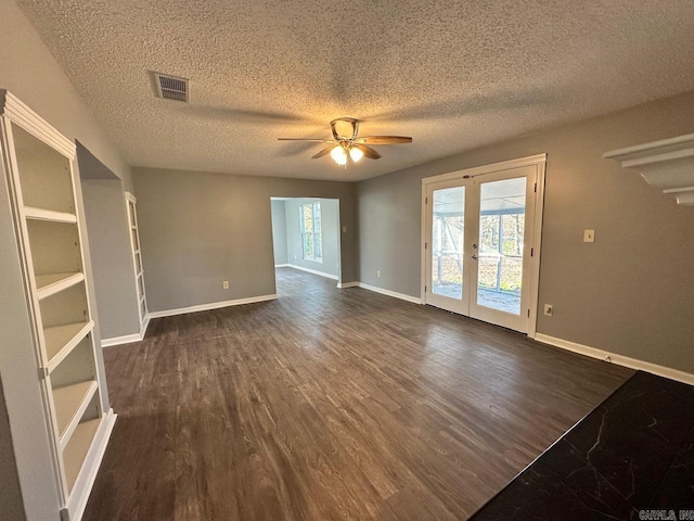 unfurnished room with ceiling fan, dark hardwood / wood-style flooring, a textured ceiling, and french doors