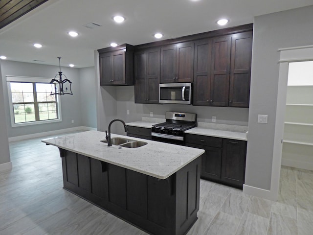 62 Highland Cove Dr, Highland, AR 72542 - kitchen featuring stainless steel appliances, a sink, baseboards, dark brown cabinets, and light stone counters
