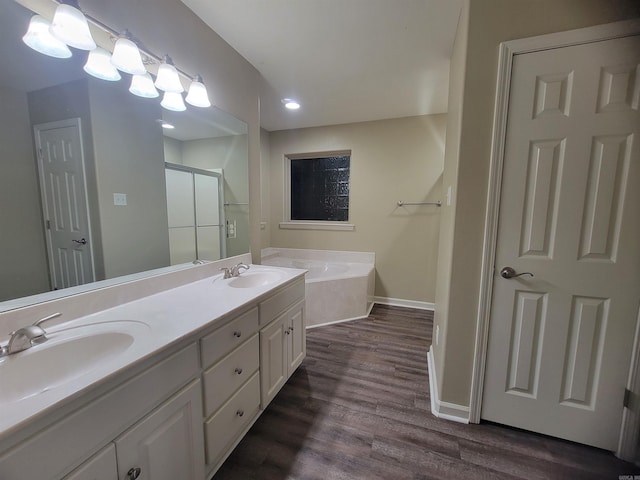 bathroom with hardwood / wood-style floors, vanity, and shower with separate bathtub