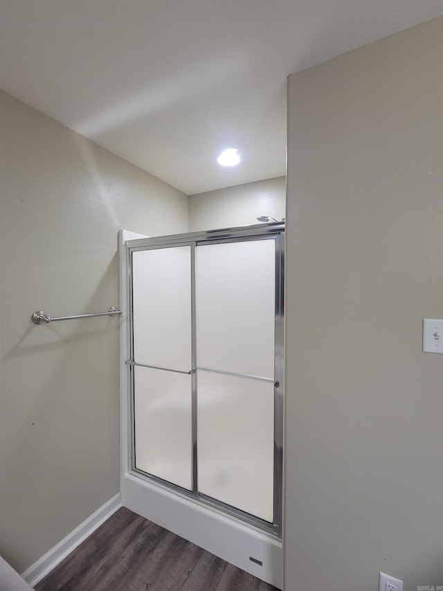 bathroom with hardwood / wood-style floors and an enclosed shower