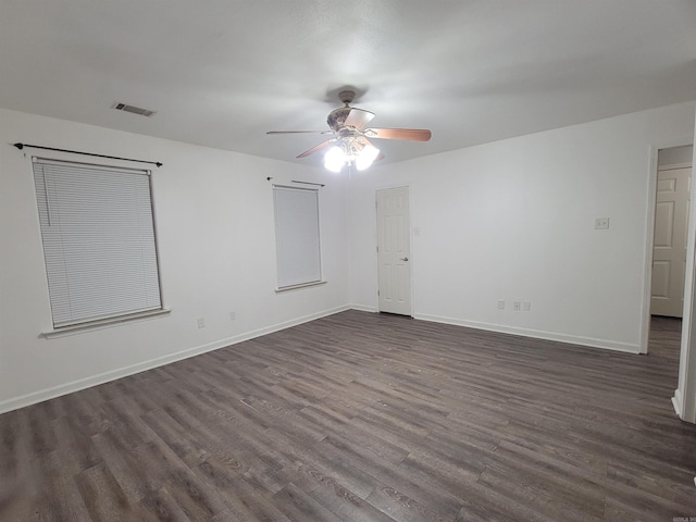 empty room with ceiling fan and dark hardwood / wood-style flooring