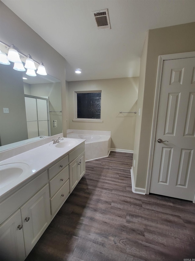 bathroom with wood-type flooring, vanity, and a tub