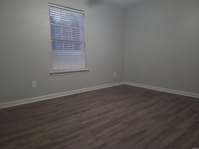 unfurnished room with dark wood-type flooring