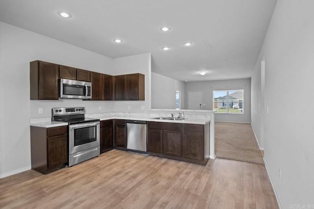 kitchen featuring dark brown cabinets, sink, stainless steel appliances, and light hardwood / wood-style flooring