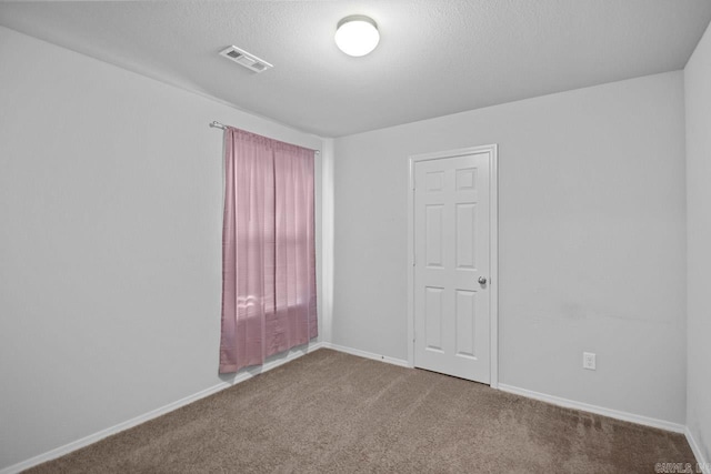 carpeted spare room with a textured ceiling