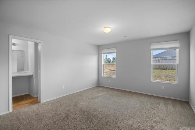 carpeted empty room with a healthy amount of sunlight