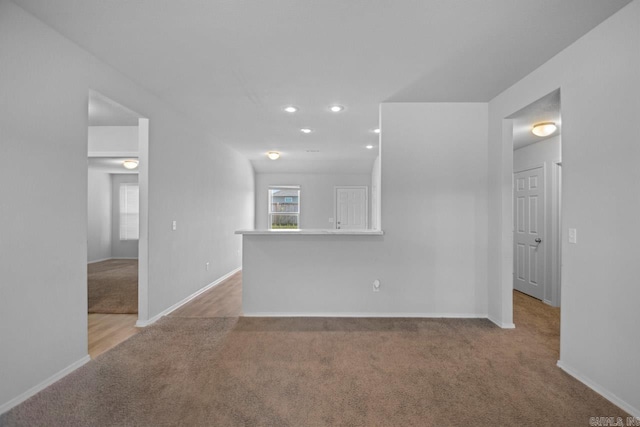 unfurnished living room with light colored carpet