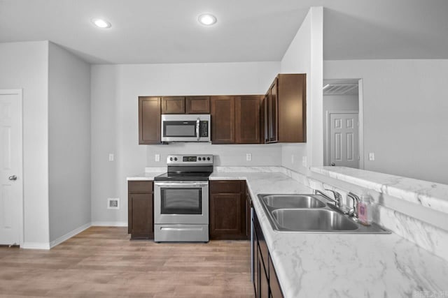 kitchen with dark brown cabinets, light hardwood / wood-style floors, sink, and stainless steel appliances