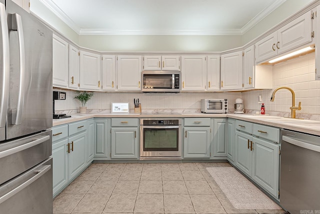 kitchen featuring sink, stainless steel appliances, light tile patterned floors, decorative backsplash, and white cabinets