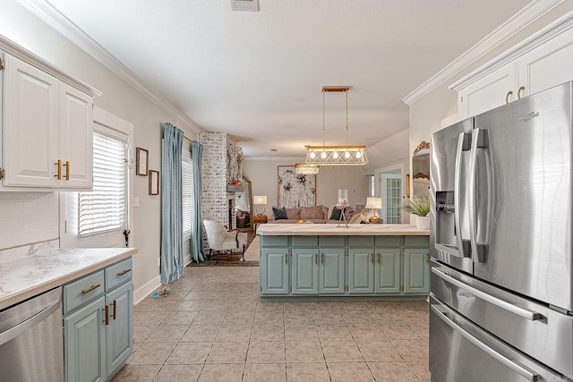 kitchen featuring white cabinetry, ornamental molding, decorative light fixtures, and appliances with stainless steel finishes