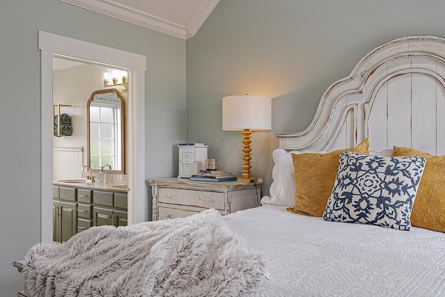 bedroom with connected bathroom, vaulted ceiling, ornamental molding, and sink