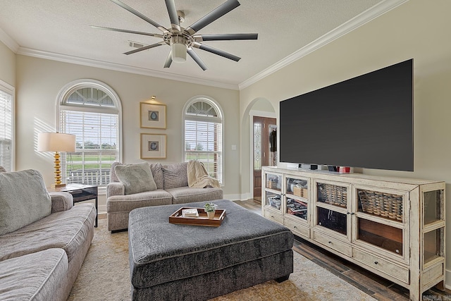 living room featuring hardwood / wood-style floors, ceiling fan, crown molding, and a textured ceiling