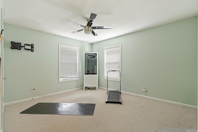 exercise area featuring carpet, a textured ceiling, and ceiling fan