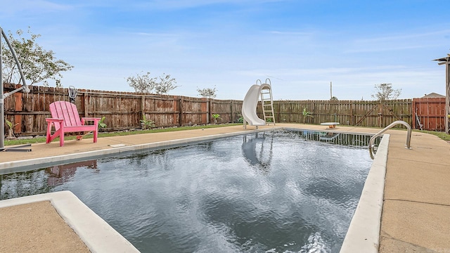 view of swimming pool with a diving board and a water slide