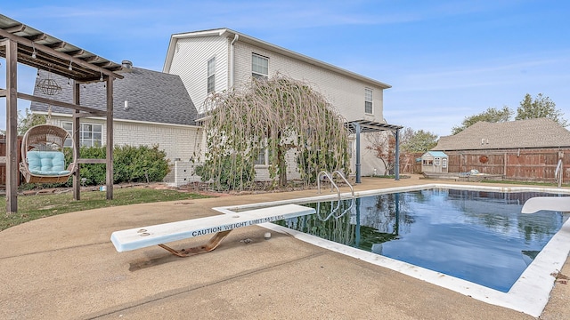 view of swimming pool with a diving board and a patio