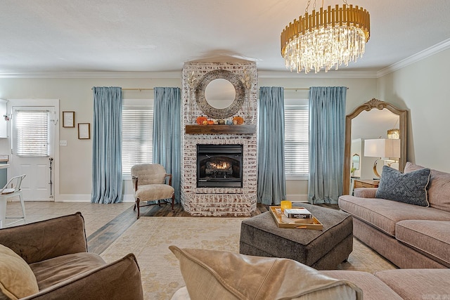 living room with a brick fireplace, ornamental molding, a textured ceiling, a notable chandelier, and light hardwood / wood-style floors