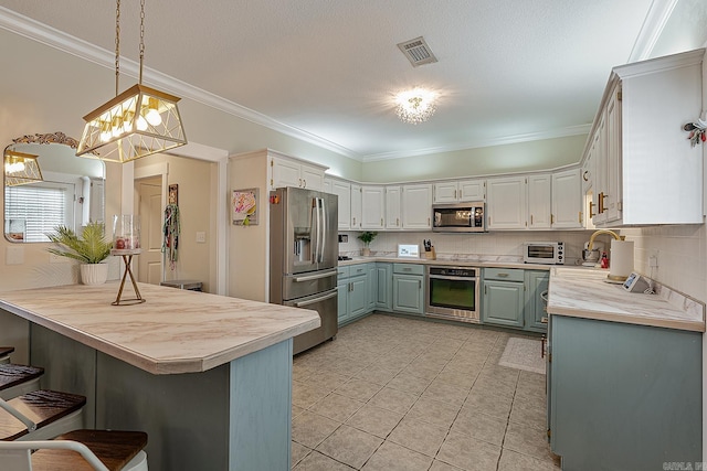 kitchen featuring kitchen peninsula, decorative light fixtures, stainless steel appliances, and white cabinets