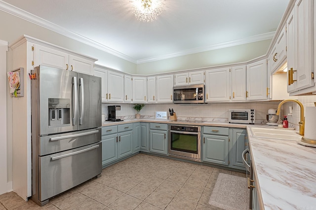 kitchen featuring crown molding, sink, white cabinets, and appliances with stainless steel finishes