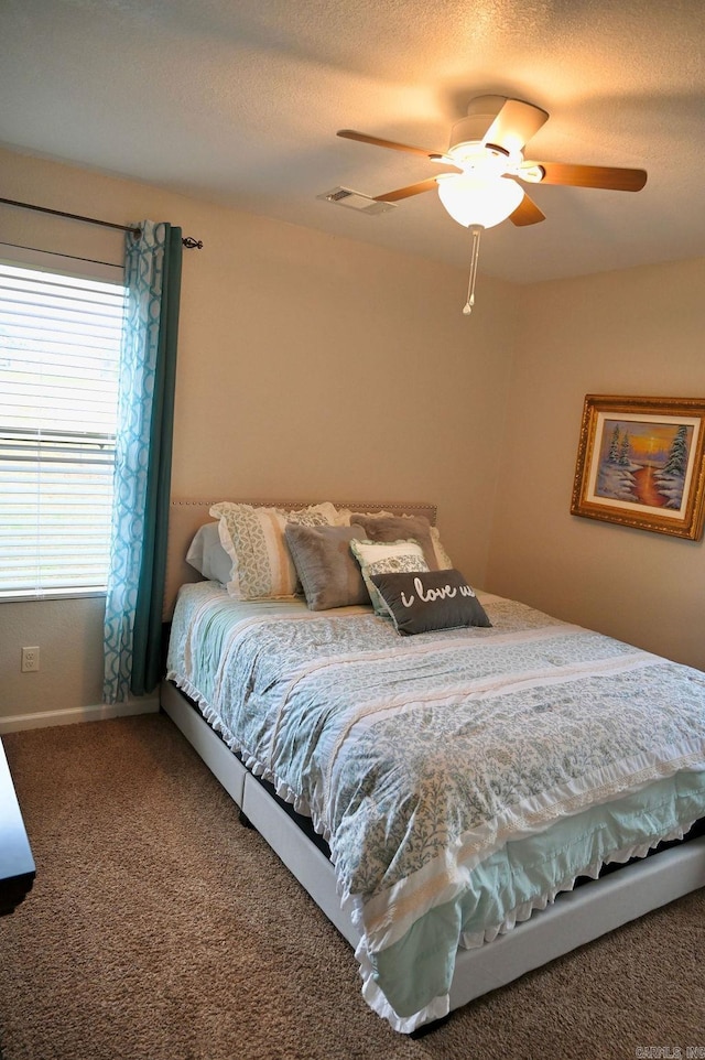 bedroom with carpet flooring, ceiling fan, and a textured ceiling