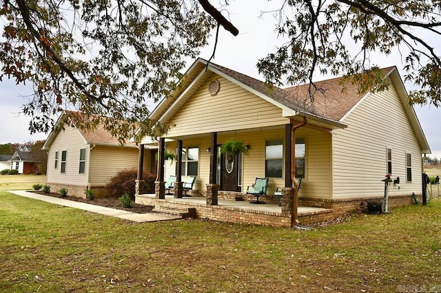 back of property with a porch and a lawn