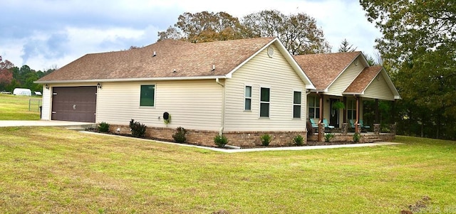 view of front of property featuring a porch, a garage, and a front lawn