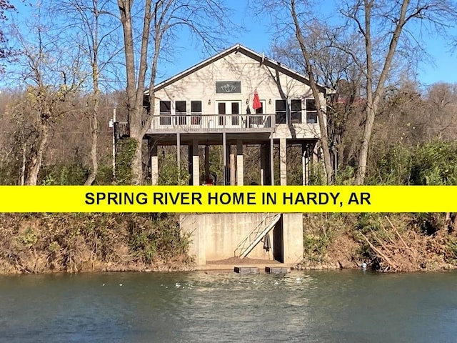 back of property with a deck with water view