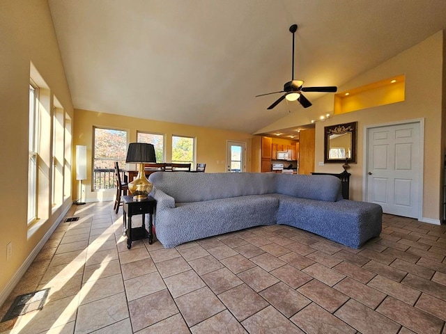 tiled living room with ceiling fan and high vaulted ceiling