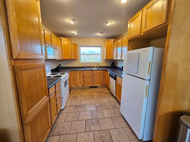 kitchen with light tile patterned floors, white appliances, and sink