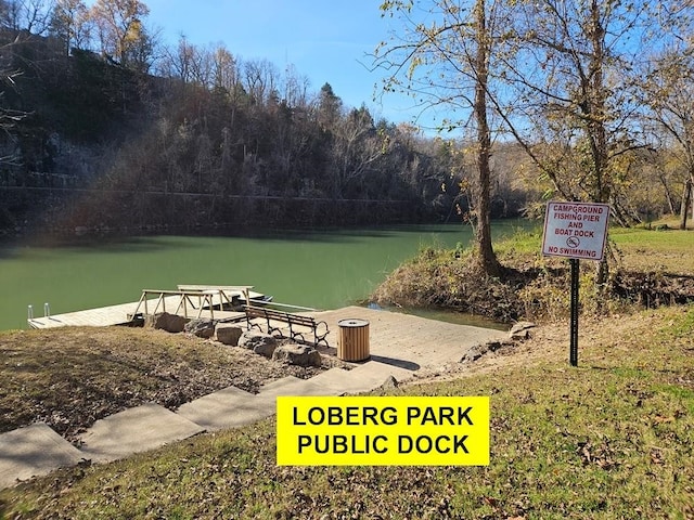 surrounding community featuring a boat dock and a water view