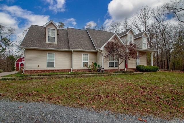 cape cod home with an outbuilding and a front yard