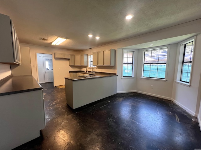 kitchen with kitchen peninsula, a textured ceiling, and sink