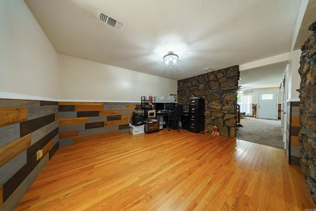 interior space featuring a textured ceiling and light hardwood / wood-style flooring