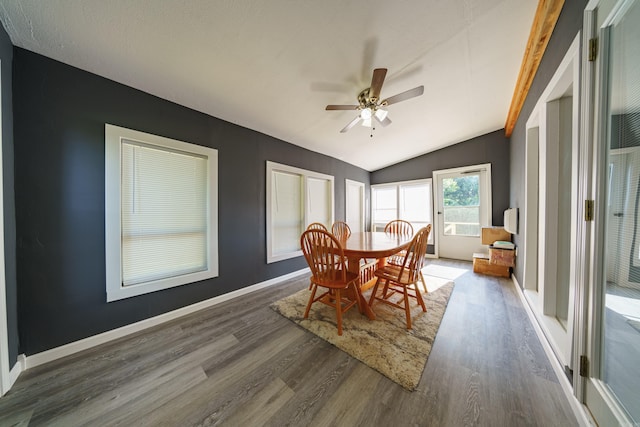 dining room featuring dark hardwood / wood-style flooring, vaulted ceiling with beams, and ceiling fan