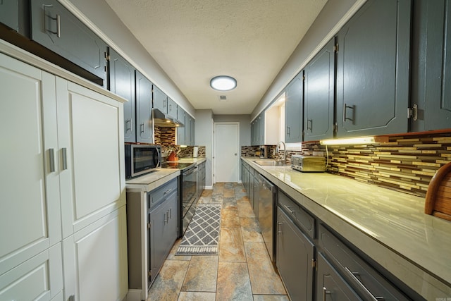 kitchen with decorative backsplash, sink, a textured ceiling, and appliances with stainless steel finishes