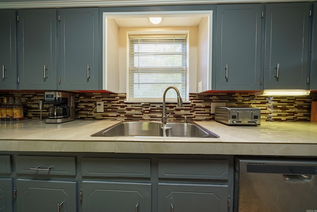 kitchen featuring gray cabinets, tasteful backsplash, stainless steel dishwasher, and sink