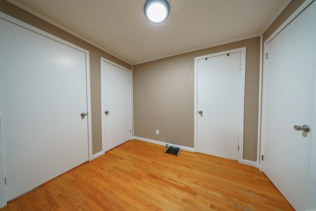 interior space with crown molding and light wood-type flooring