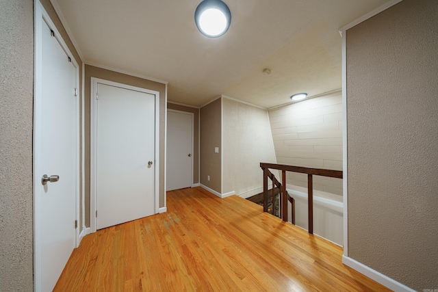 hallway with crown molding and hardwood / wood-style floors