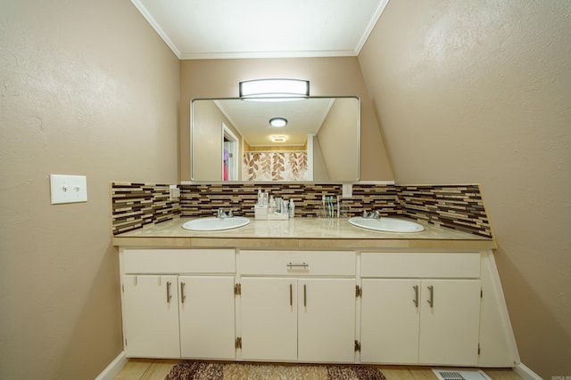 bathroom featuring tasteful backsplash, crown molding, and vanity