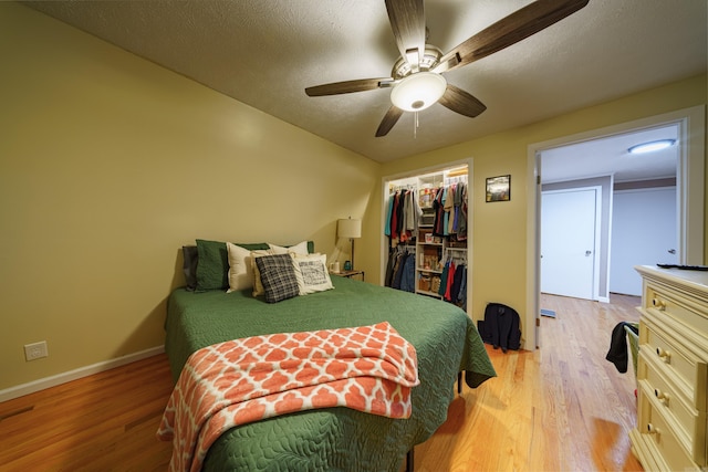 bedroom with ceiling fan, a closet, a textured ceiling, and light wood-type flooring