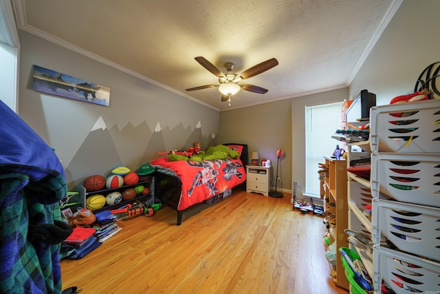 bedroom featuring hardwood / wood-style floors, a textured ceiling, ceiling fan, and ornamental molding